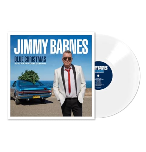 Jimmy Barnes standing in a white tuxedo next to a blue car with vinyl record.