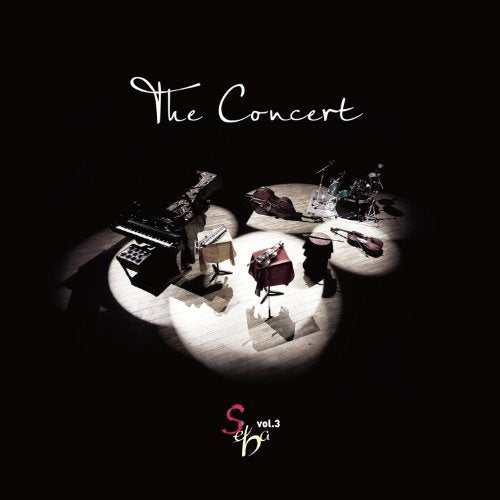 CD cover: dimly lit stage with musical instruments and text “The Concert”.
