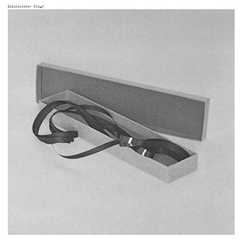 Black straps and a vinyl record partially visible in an open box.