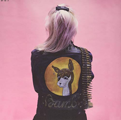 Person with blonde hair wearing a black jacket with a dog patch.