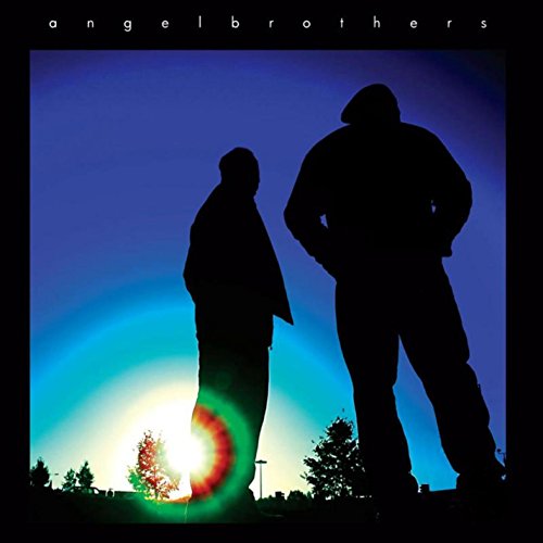 Silhouettes of two men against a blue sky with a colorful sunrise.