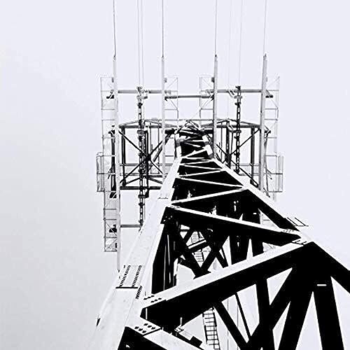 Black and white image of a tall, industrial metal transmission tower.