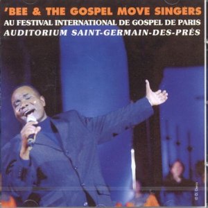 Gospel singer Em’bee performing with raised hands at a Paris festival.