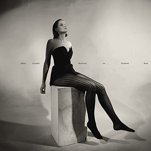 Black and white album cover featuring a woman sitting on a cube.