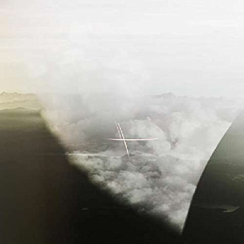 Aerial view of a small airplane flying above clouds.