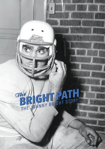 Black and white portrait of a football player holding his helmet.