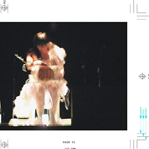 Björk in a pale dress, performing on a dark stage with lighting effects.