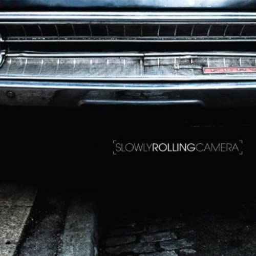 Dark album cover featuring a car bumper and the band's name.