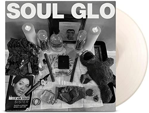 Vinyl record cover with candles, a teddy bear, and portrait photos.