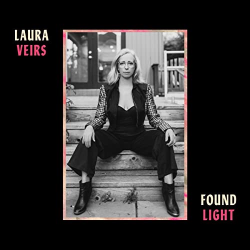 Black and white portrait of Laura Veirs seated on wooden steps.