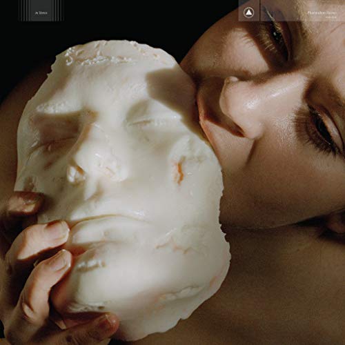 Person holding a pale, sculpted face close to their own.