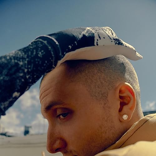 Close-up of a man with a shaved head wearing a patterned bandana.