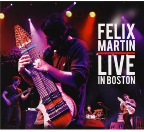 Felix Martin playing a large harp guitar on stage in Boston.