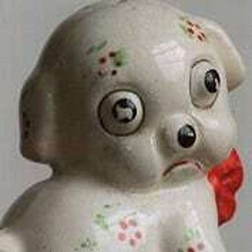 Close-up of a vintage ceramic dog figurine with painted details.