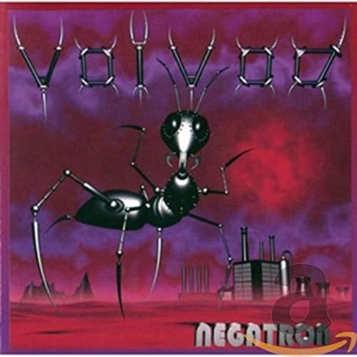A metallic ant stands in a red landscape before a factory under purple skies.