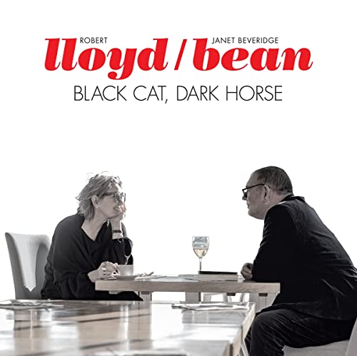 CD cover: two people seated at a table, black and white.