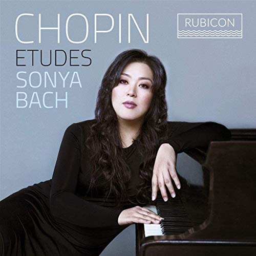 Pianist Sonya Bach sits at a grand piano on this Chopin Etudes album cover.