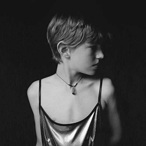 Black and white portrait of Finn Andrews with short hair and a necklace.