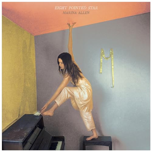Album cover: woman reaching up near a piano and golden shape.
