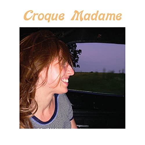 Profile of a smiling woman looking out a car window at a field.