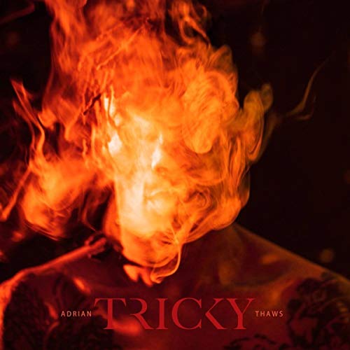 Album cover for Tricky's "Adrian Thaws" featuring a fiery, blurred portrait.