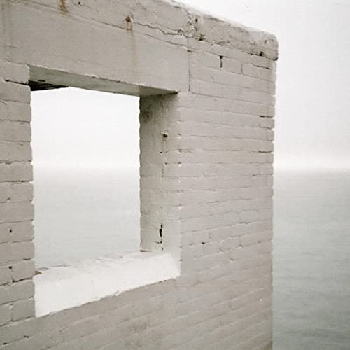 Concrete structure with a window overlooking a hazy, gray sea.