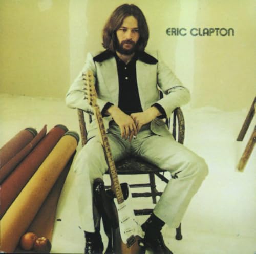 Eric Clapton in a light suit with a guitar, album cover.