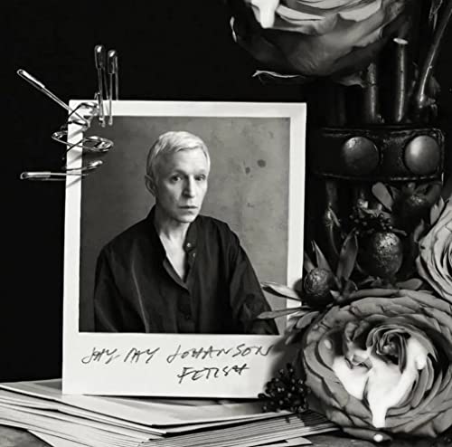 Black and white portrait of a person with flowers and pins.