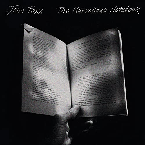 Black and white album cover featuring an open notebook and a hand.