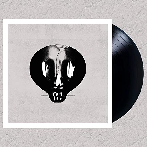 Vinyl record with album art of a distorted skull and white hands.