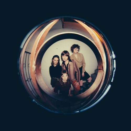 Four people stand in a circular stairwell, viewed through a fisheye lens.