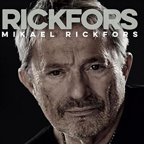 Close-up portrait of musician Mikael Rickfors on a dark background.