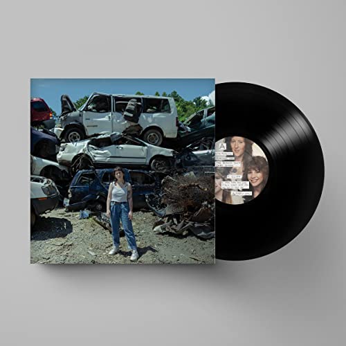 Vinyl record and album cover featuring a woman in a junkyard.