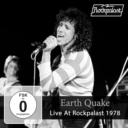 Black and white concert photo of a singer with curly hair at a microphone.