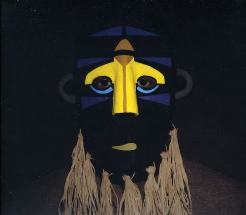 Dark mask with yellow and blue geometric shapes, fringed bottom.