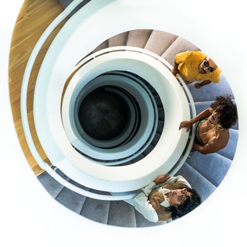 Overhead view of three people on a circular staircase.