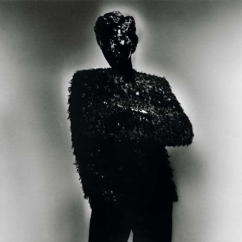 Black and white portrait of a figure obscured by dark, textured material.