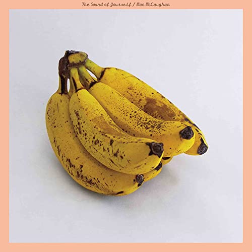 Bunch of yellow bananas against a pale orange square background.