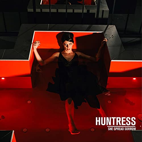 Woman in black dress lying on red geometric structure.