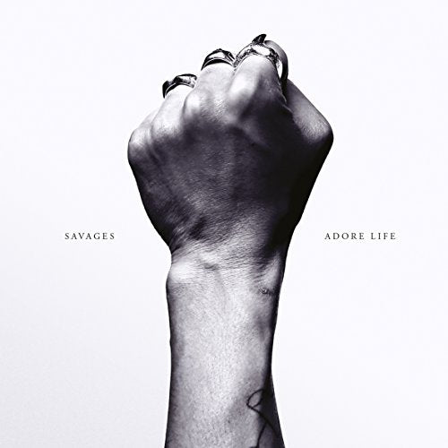 Black and white image of a clenched fist with multiple rings.