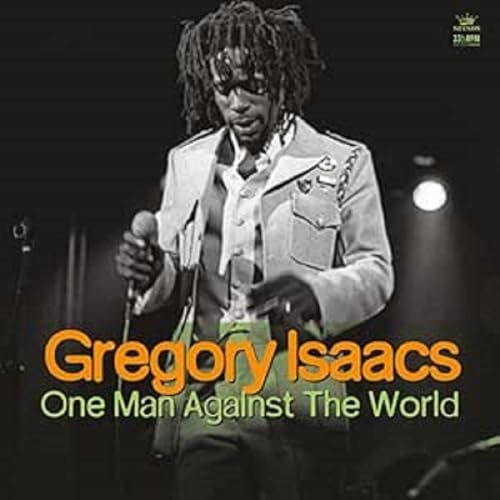 Black and white photo of Gregory Isaacs singing into a microphone on stage.