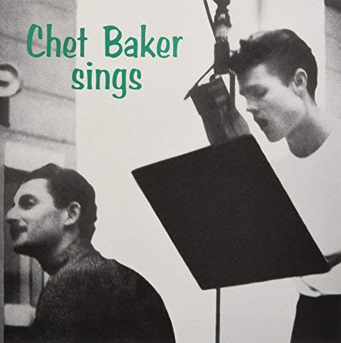 Black and white photo of Chet Baker singing into a microphone.