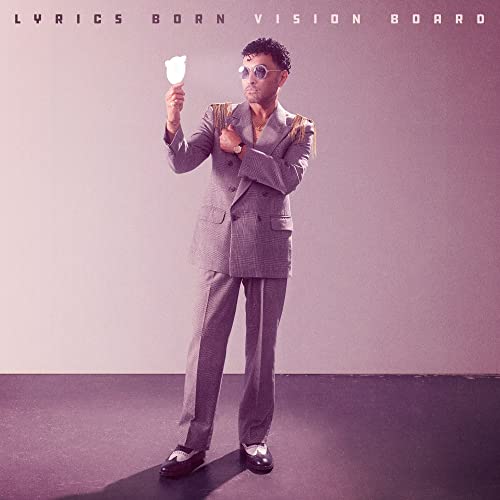 Lyrics Born album cover: man in suit holding a small sculpture.