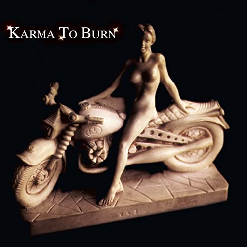 Statue of a nude woman on a motorcycle, dark background.