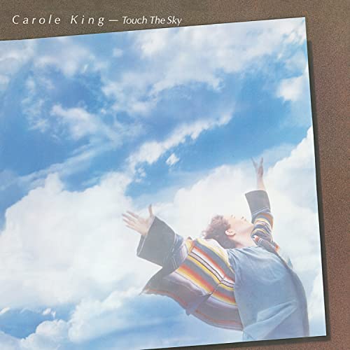 Carole King album cover: woman with arms raised to a cloudy sky.