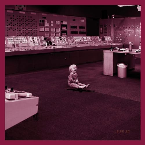 Child sits in a control room filled with complex machinery.