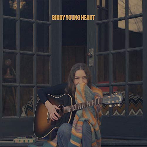 CD cover: woman with guitar seated by a window, wrapped in a blanket.