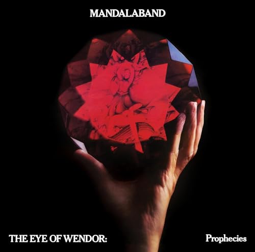 Hand holding a faceted red gem with a figure inside, album cover.