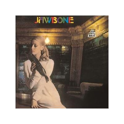 Vinyl record cover featuring a woman in a white dress, dark background.