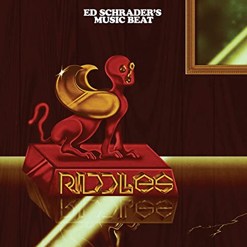 Album cover for Ed Schrader's Music Beat - Riddles, featuring a red sphinx.